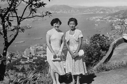 Two elegantly dressed ladies pose on Victoria Peak. Central District lies far below. The photo is from between late 1951 and early 1952 Lee Fook Chee