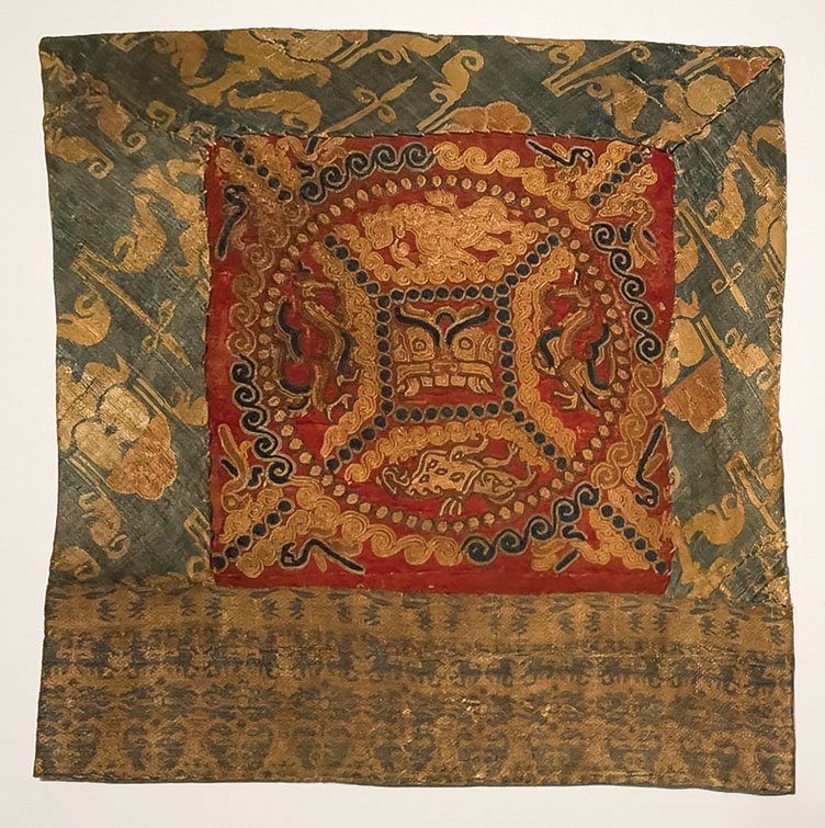 Pillow end with animal mask in pearl roundel, Three Kingdoms period to Jin dynasty (220-420 CE), Embroidery, polychrome silk threads on silk damask; weft-faced compound tabby (taqueté), polychrome silk threads; warp-faced compound tabby, polychrome silk threads, Chirs Hall