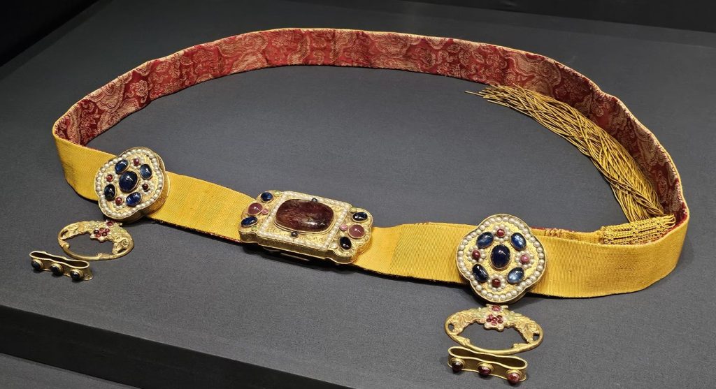 Festive robe belt, Brocaded satin, polychrome and metallic-wrapped silk threads, metal gilt, sapphires, rubies, pearls, China, Qing dynasty, about 18th to 19th century, The Chris Hall Collection at the Hong Kong Palace Museum, Global Jewellery